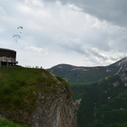 View of the Friendship Monument in Gudauri, Georgia and people paragliding on the sky